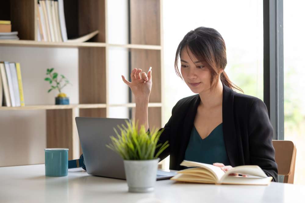 Asian businesswoman talking to colleague team in video call