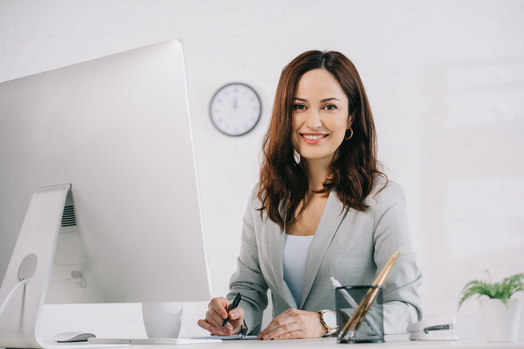 Smiling woman working at a computer, property management virtual assistant concept. 