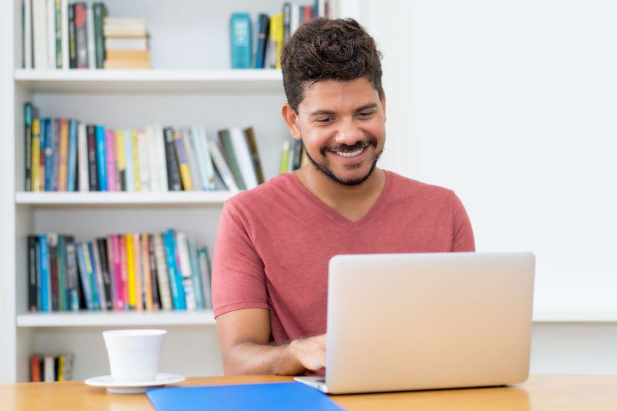 A Hispanic man at a computer delivers multilingual talent as a virtual assistant