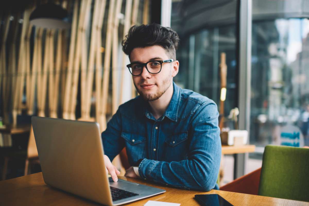 A man working at a computer as a virtual assistant helps companies reduce payroll costs