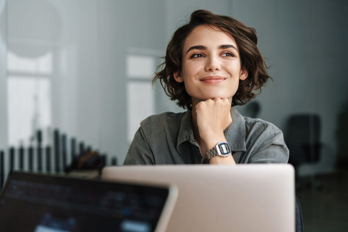 A smiling woman at a laptop, property management virtual assistants concept