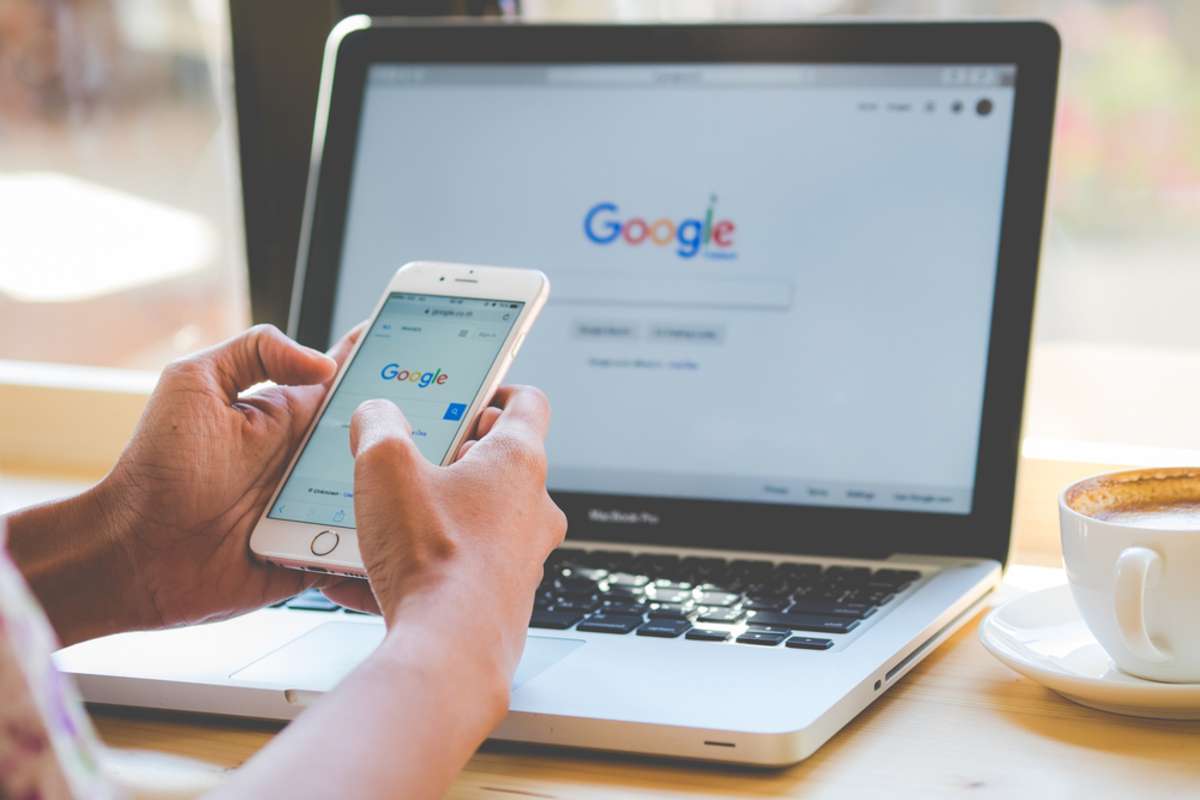 A woman is typing on Google search engine from a laptop