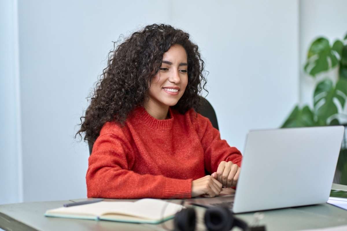 A woman works at a computer as a virtual assistant vs. employee