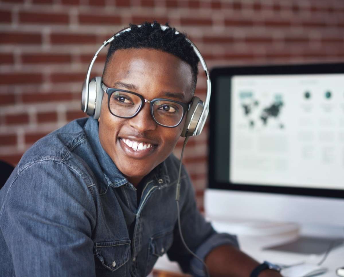 A young African man with headphones is a skilled virtual assistant for property management