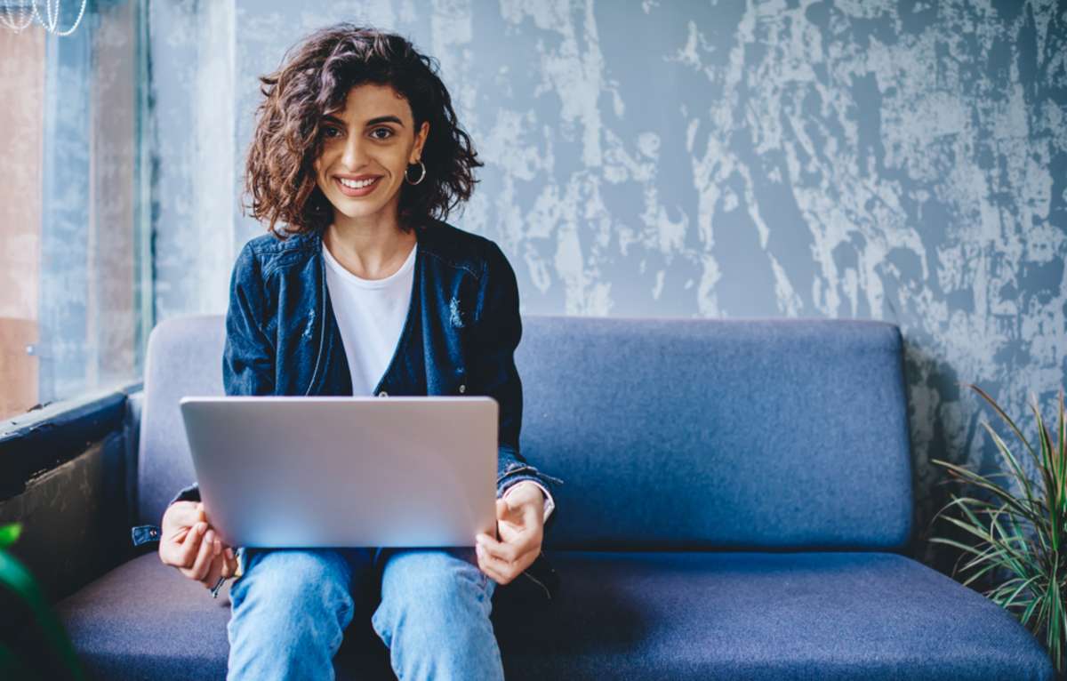 A young woman works on a laptop, virtual property management companies concept