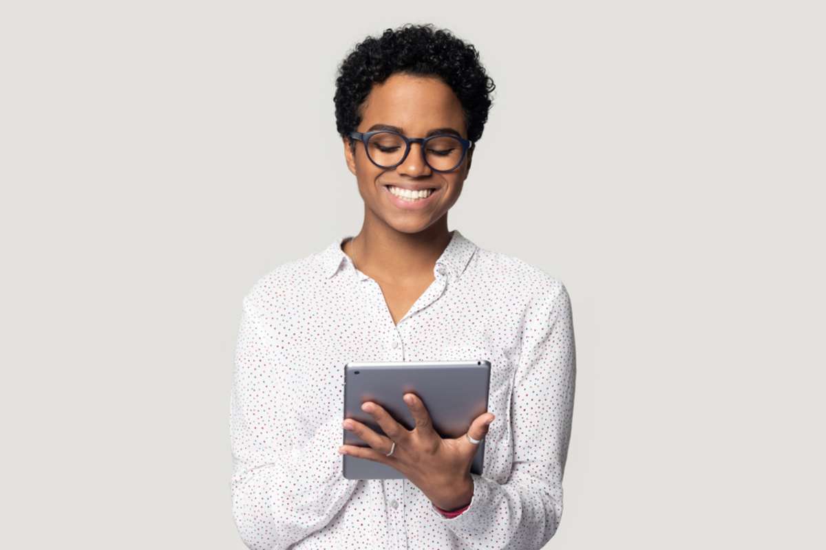 African young woman holding digital tablet isolated on gray background