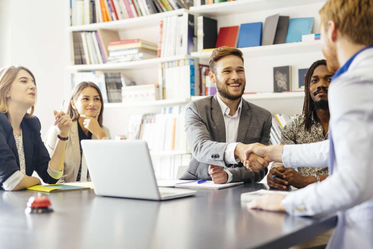 Business shaking hand with a client in office