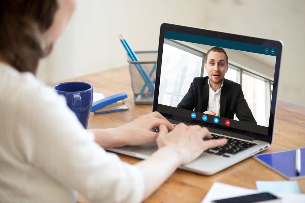 Businesswoman making video call to coworker using a laptop, property management virtual assistant concept. 