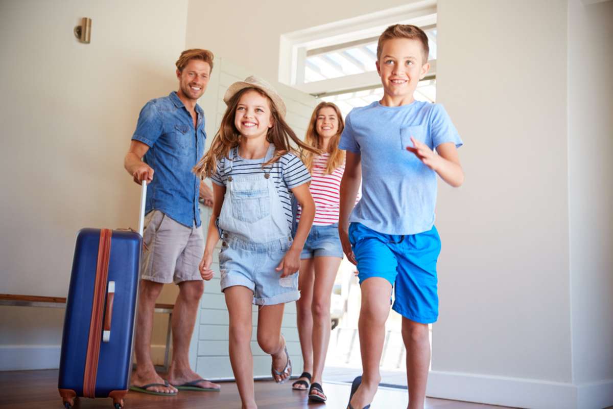 Family Arriving At Summer Vacation Rental