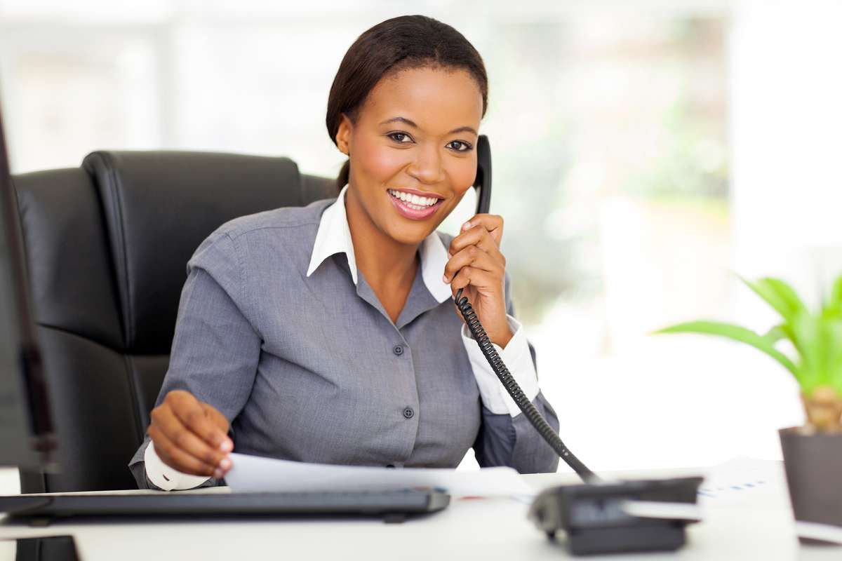 Woman in an office talking on phone, what is a personal assistant concept. 
