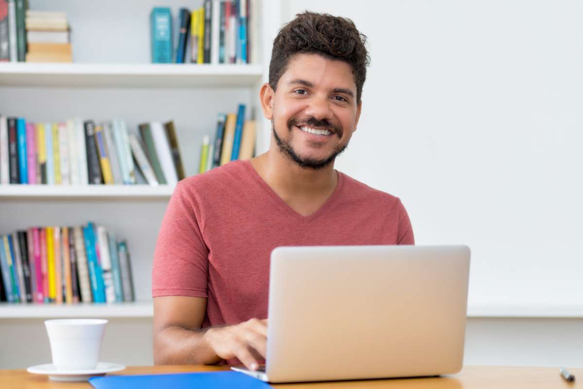 Handsome latin american man with beard working at computer at home