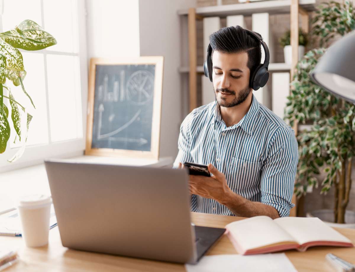 Happy casual young man working on a laptop at home