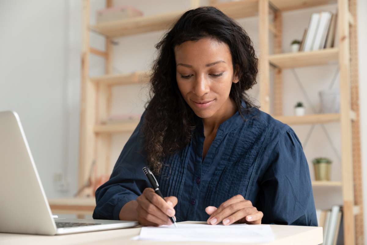 Female sitting at desk alone working as a virtual property management assistant. 