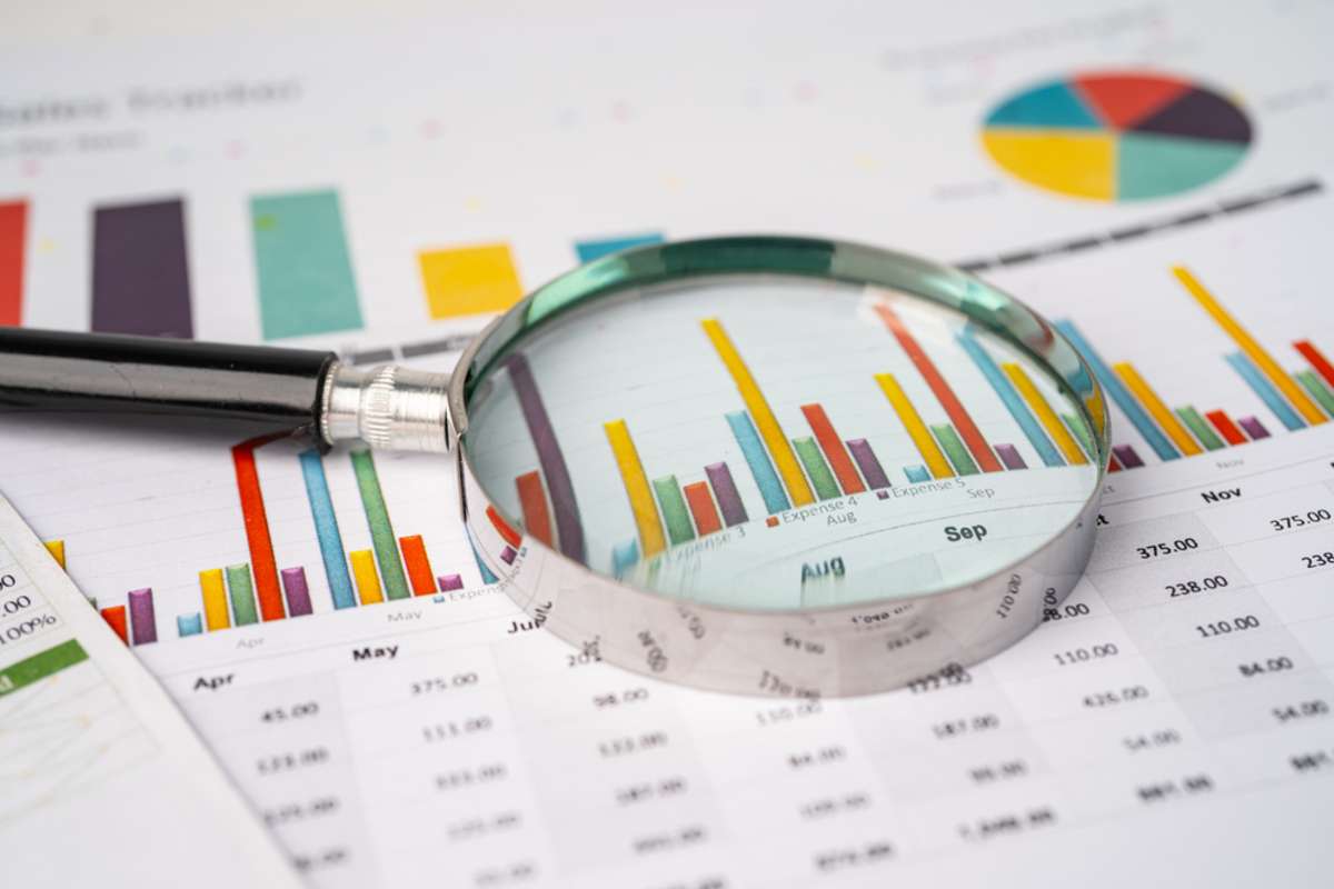 Magnifying glass on charts graphs paper. Financial development, Banking Account, Statistics