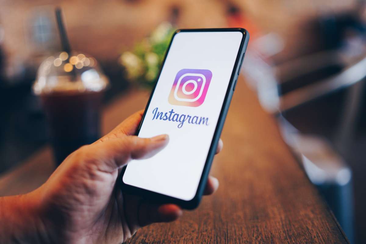 Man holding Xiaomi Mi Mix 3 with Instagram application on the screen