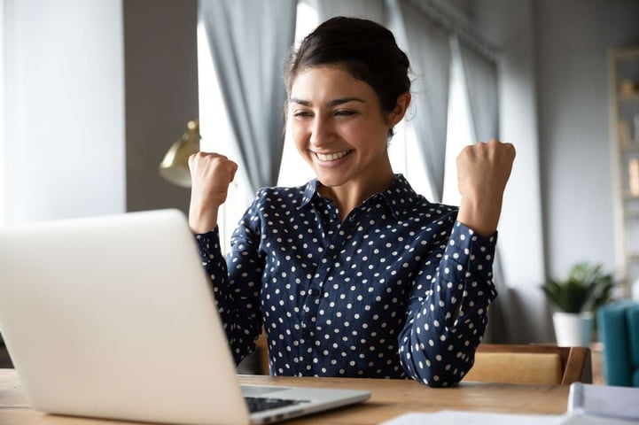 Overjoyed indian girl read incredible news on laptop celebrate success