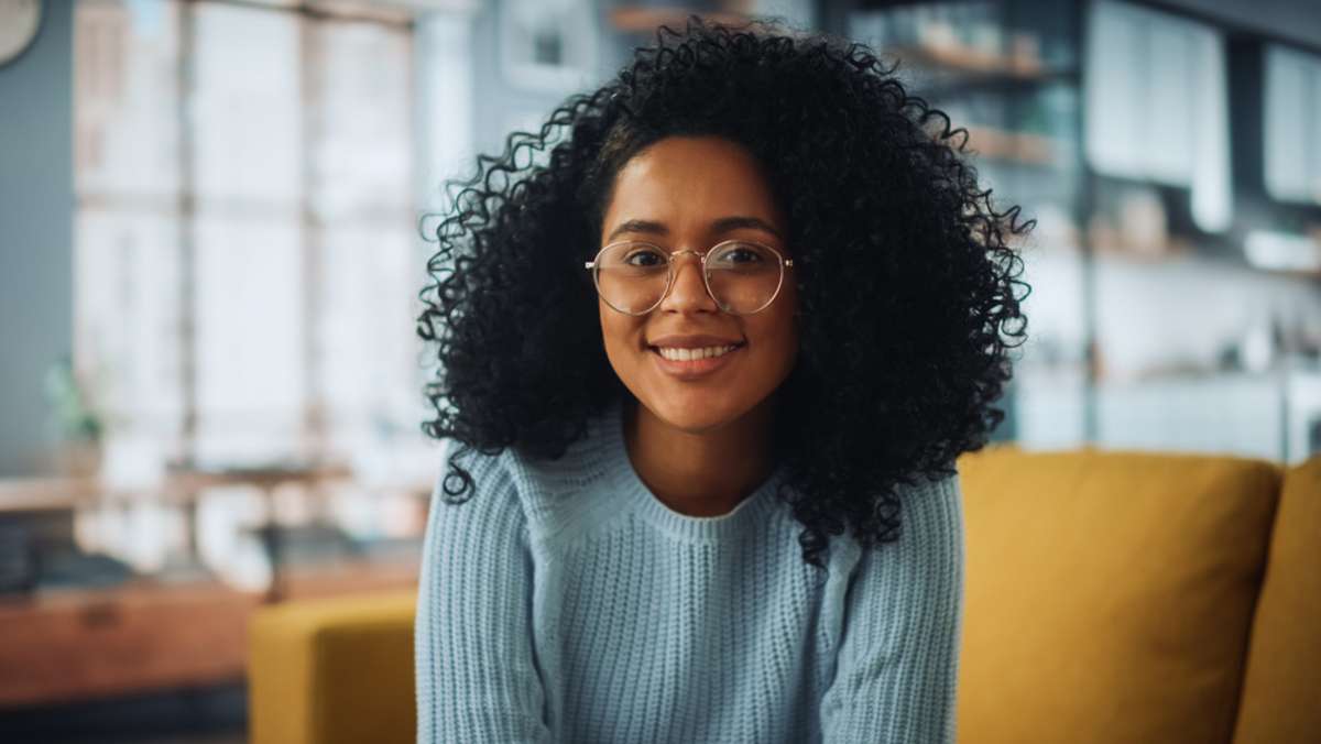 Portrait of a Beautiful Authentic Latina Female with Afro Hair Wearing Light Blue Jumper and Glasses