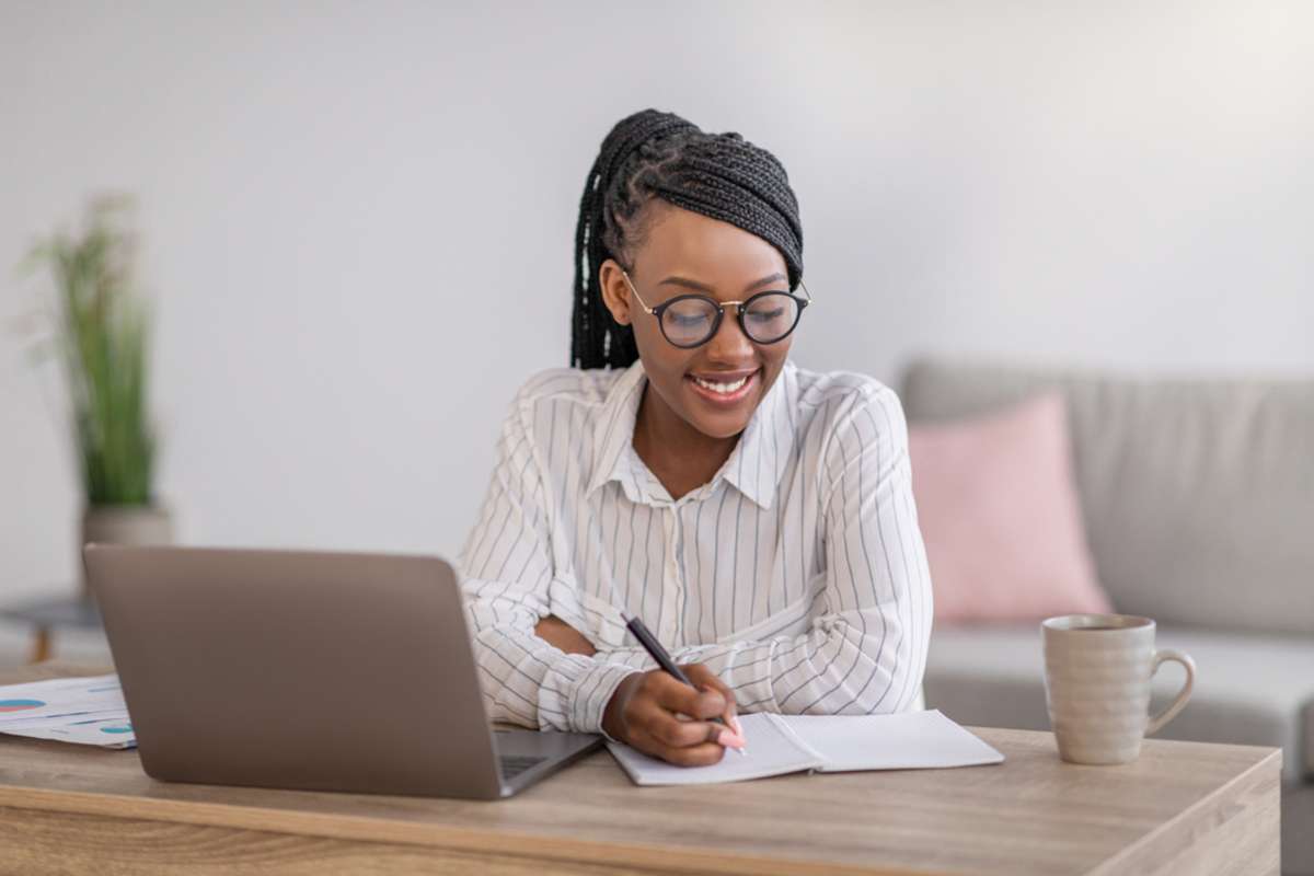Positive black business woman with stylish glasses manager working from home during COVID-19 pandemic