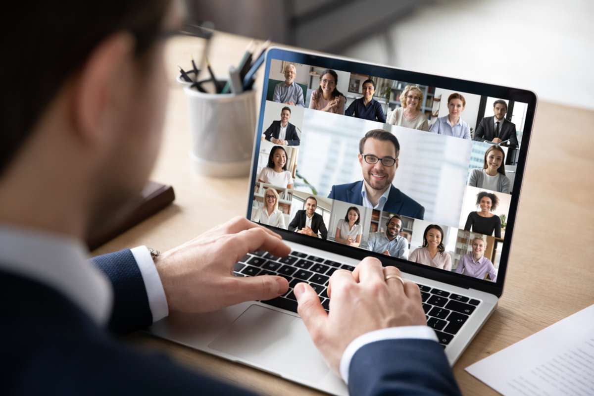 Rear view of businessman speak on web conference with diverse colleagues using laptop Webcam