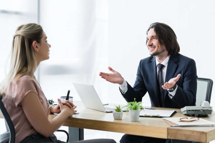 Selective focus of cheerful businessman talking with client in office
