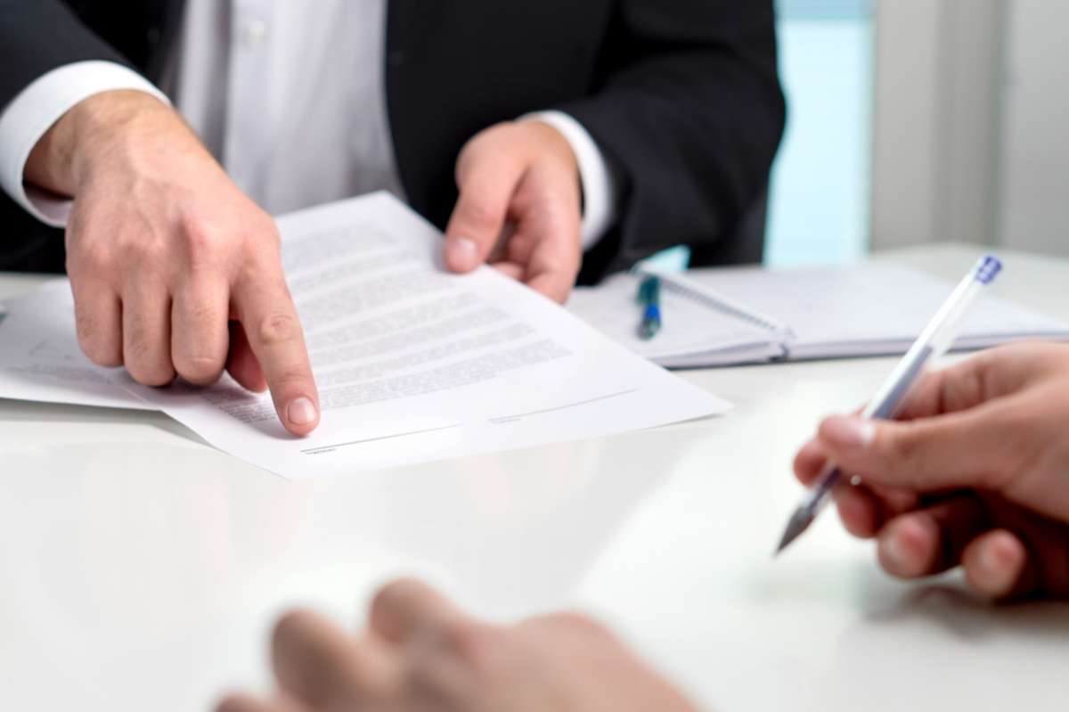 Signing a contract or agreement. Banker or lawyer showing client the line for autograph in a document paper