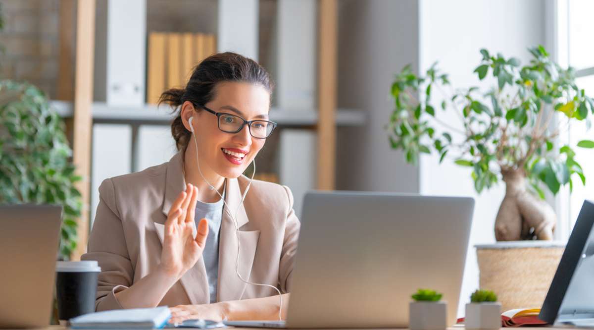 Smiling woman working at laptop, virtual marketing assistant concept