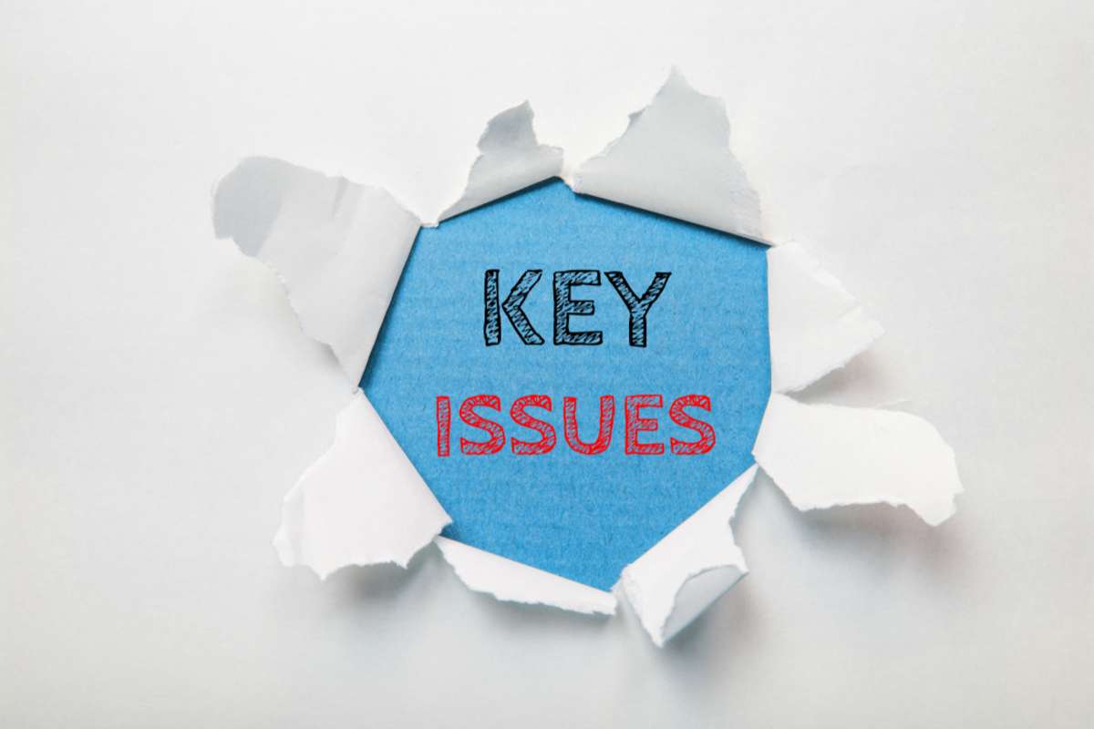 Text message KEY ISSUES on torn paper background, manage remote team concept. 