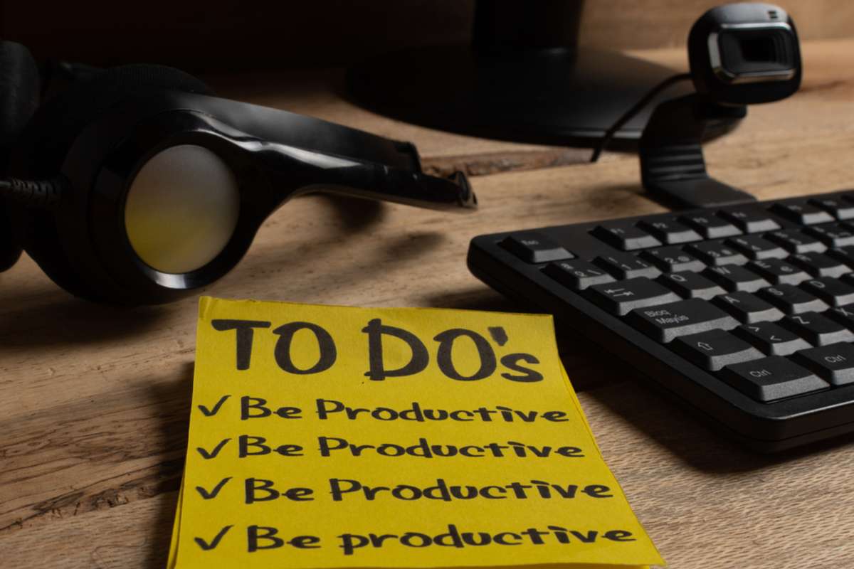 To-do list to be productive with headband, microphone and computer on wooden desk