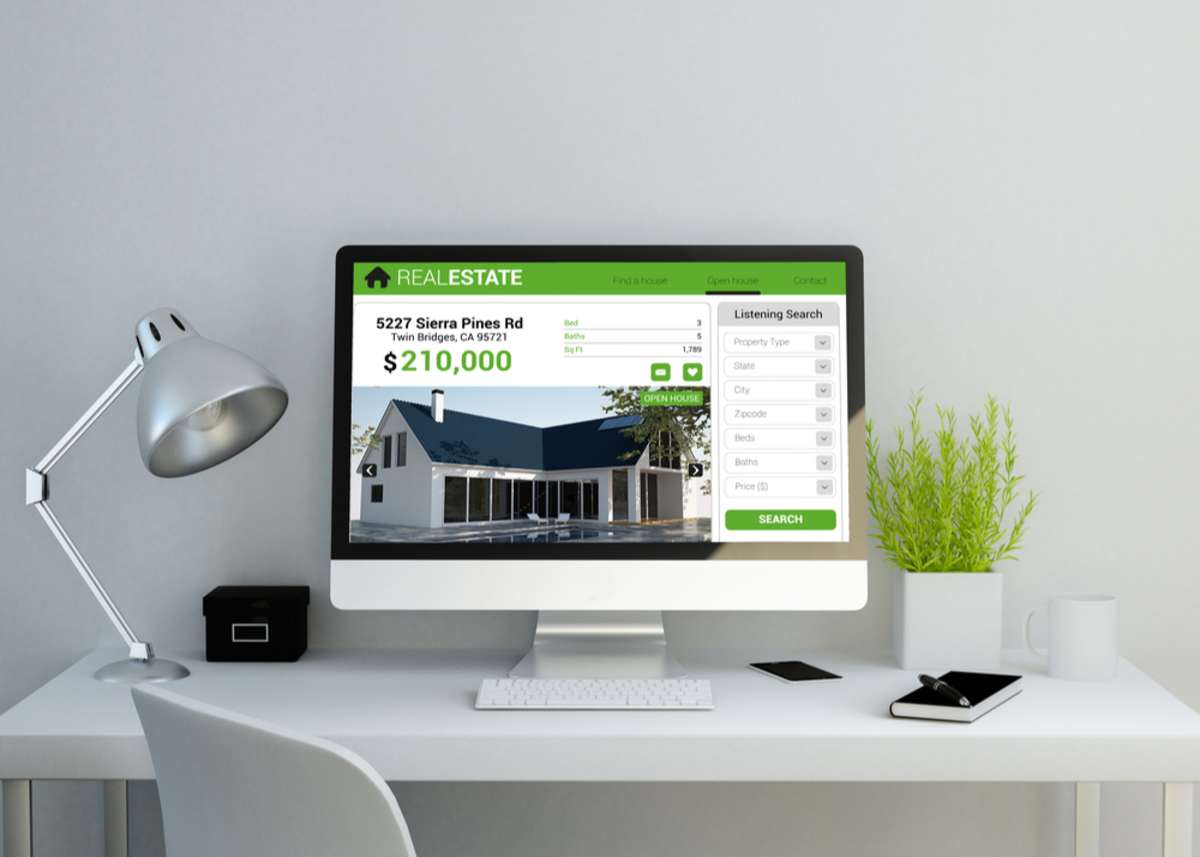 Workspace with a real estate website design on screen