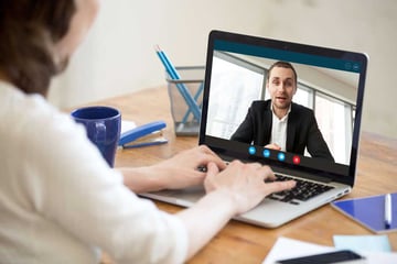 Businesswoman making video call to coworker using a laptop, property management virtual assistant concept. 