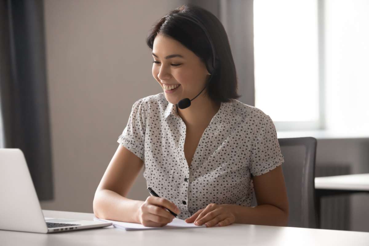 Happy asian business woman wearing headset with microphone