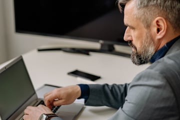Man in Suit Having Online Meeting on Laptop