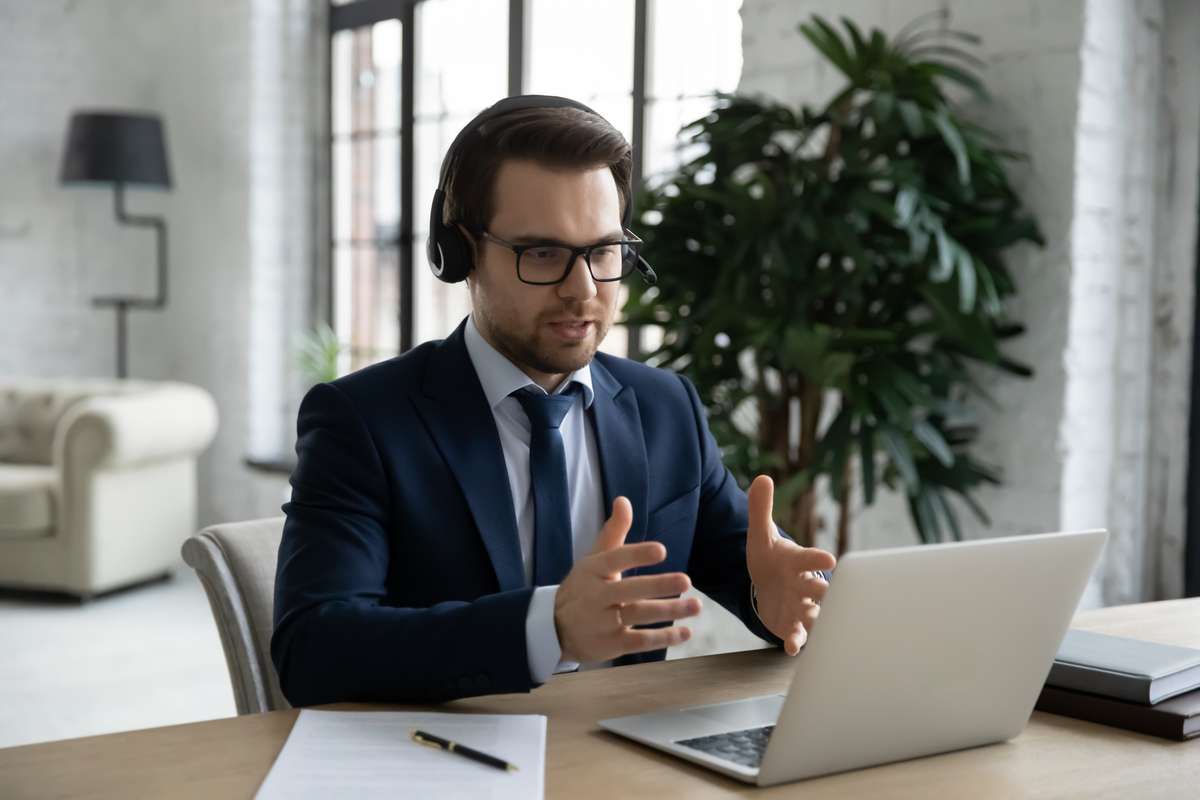 Manager in headset using laptop for video call, giving consultation (R) (S)