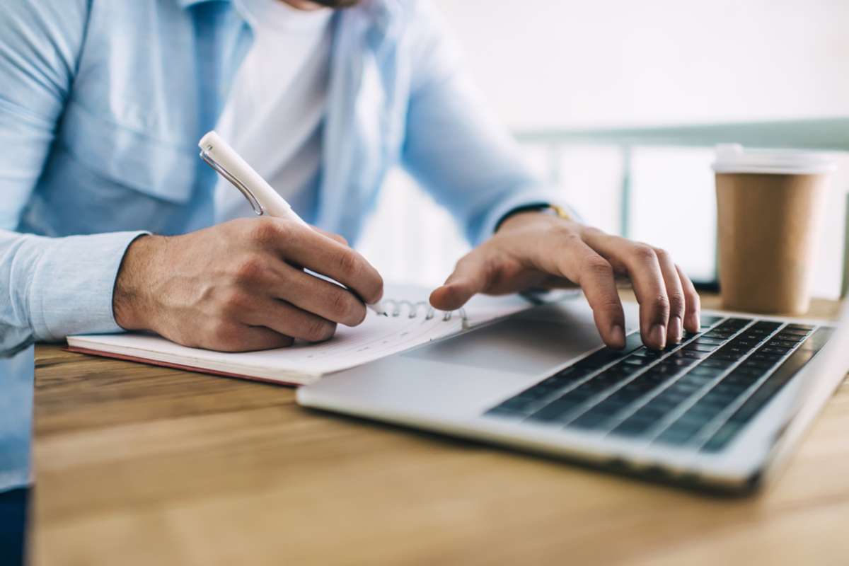 Person researching at a laptop to find a property management virtual assistant. 