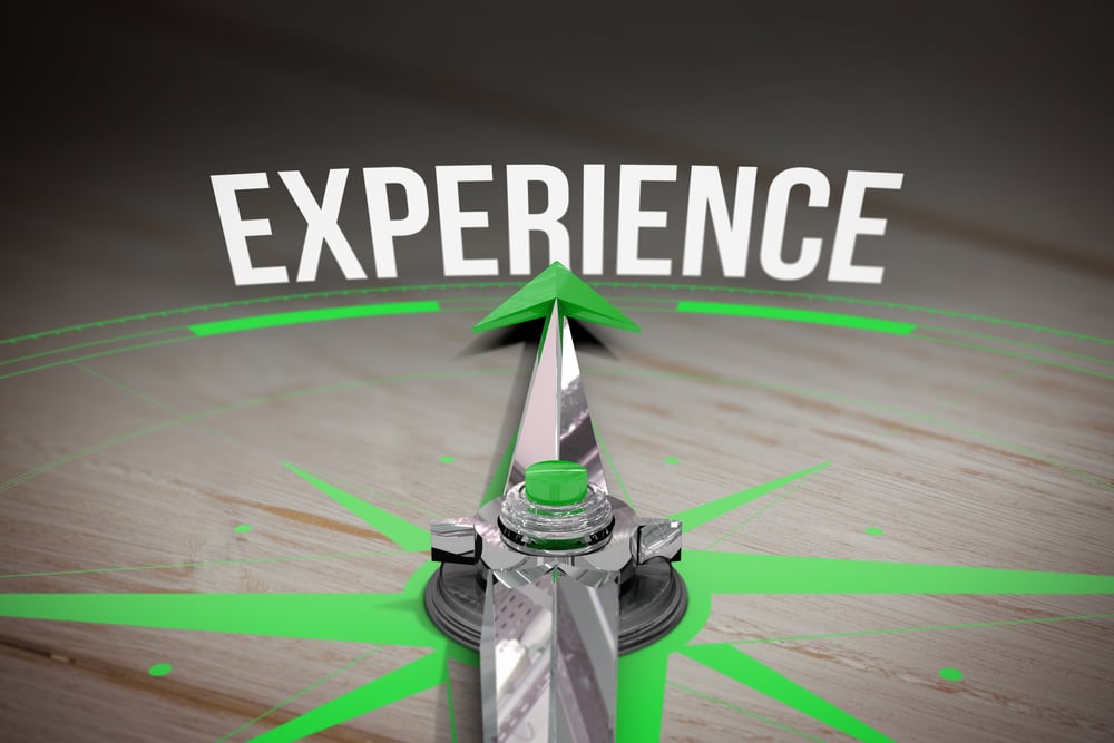 The word experience and compass against brown wooden background