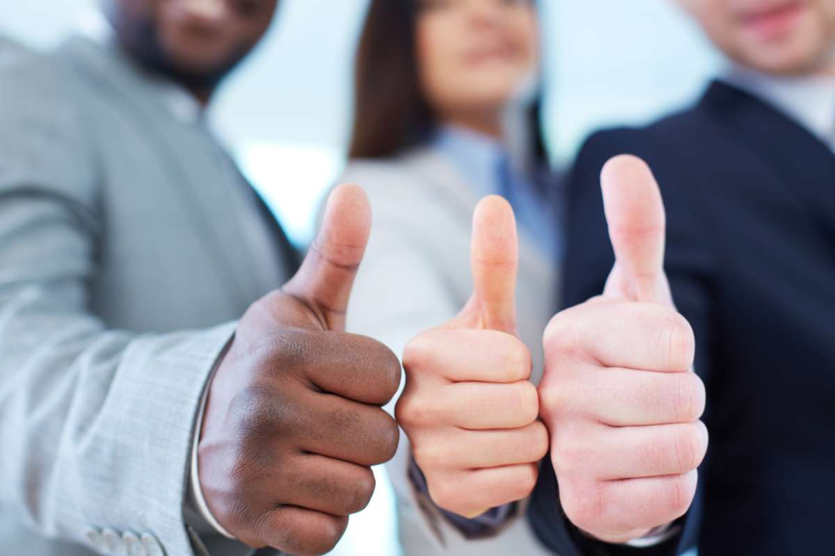 Three business partners keeping thumbs up