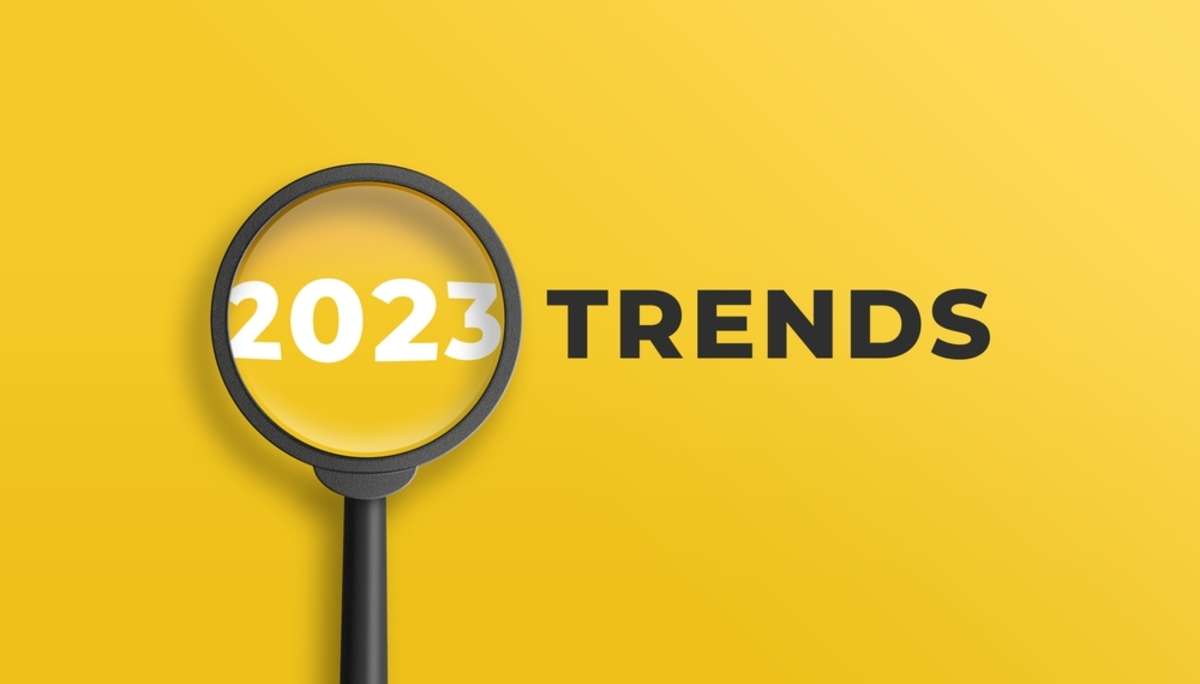 Magnifying glass magnifies 2023 trends on yellow background