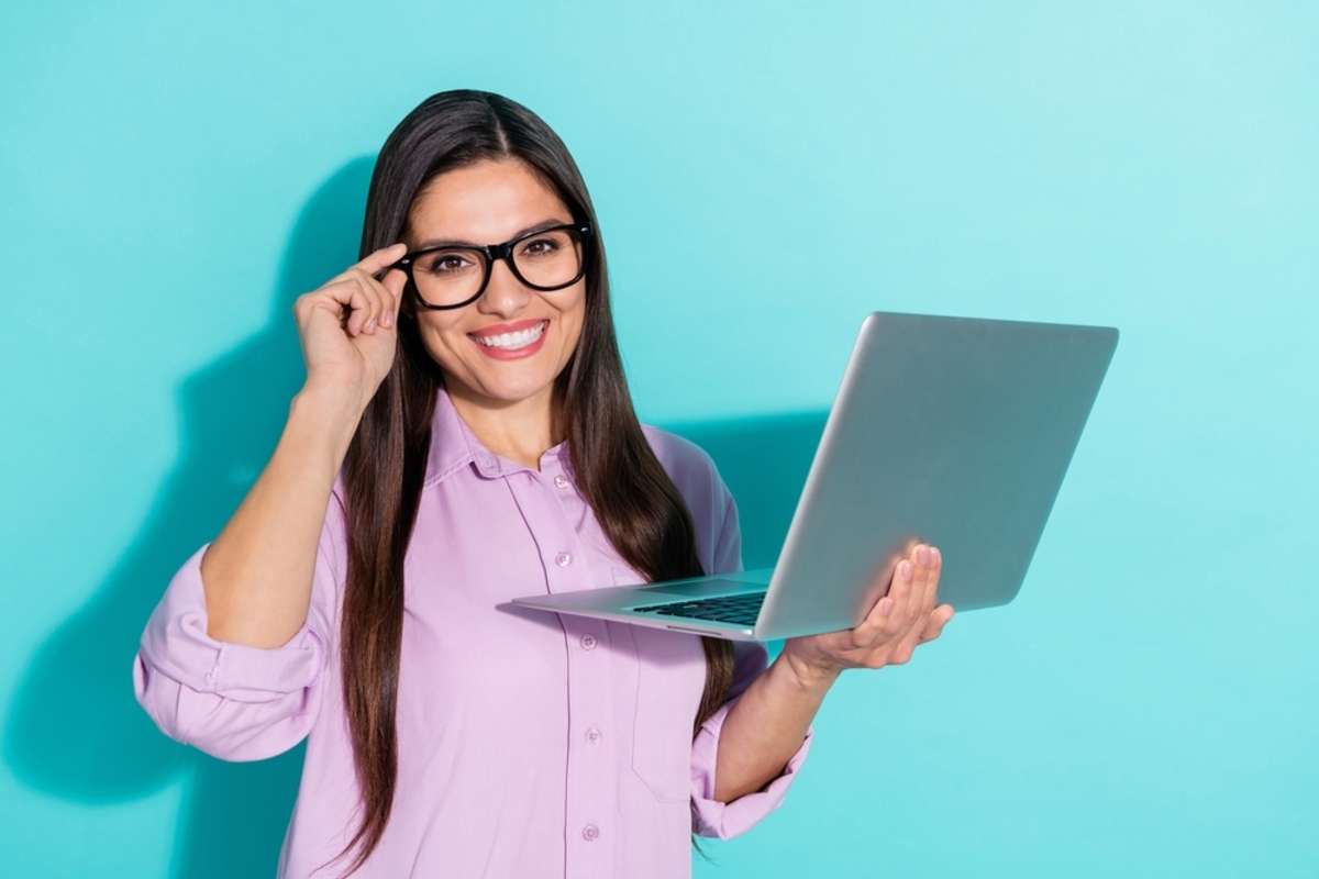 mature lady hold laptop wear eyewear violet shirt