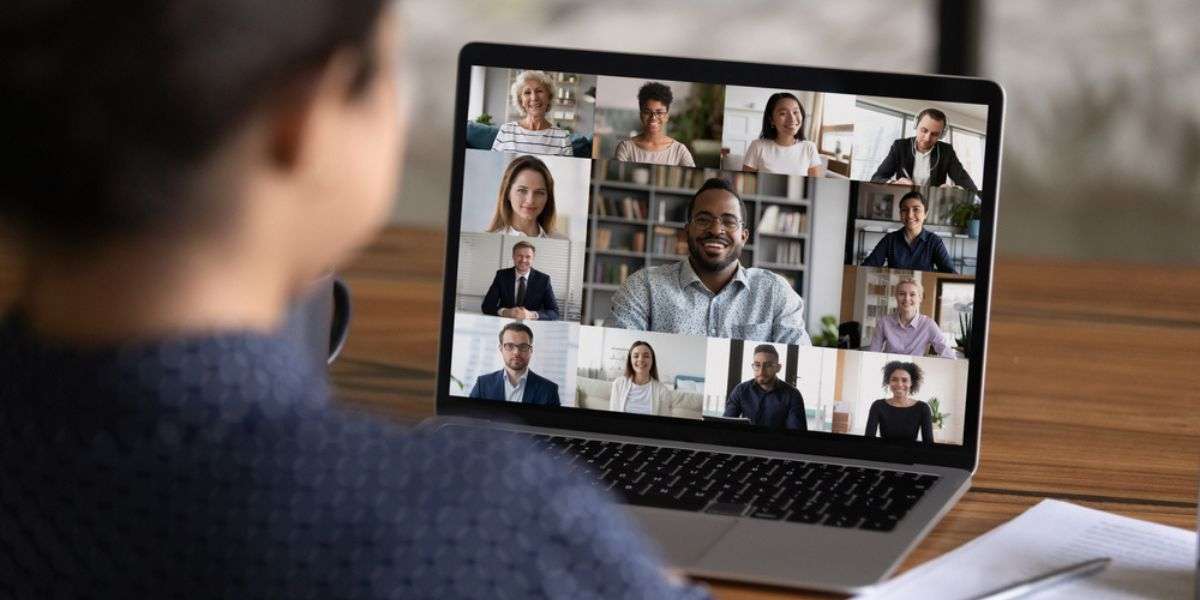 Over shoulder view of female worker have webcam digital virtual conference with diverse multiethnic colleagues